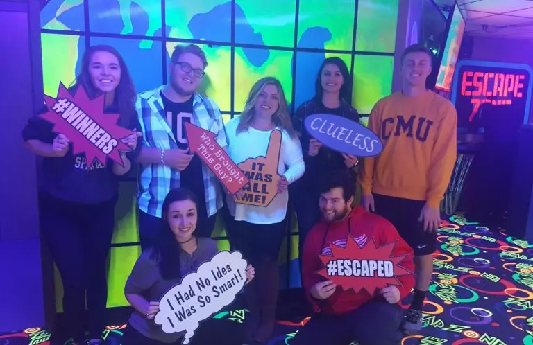 Happy group of friends celebrating victory at Escape Room Zone - Immersive team building and social fun.